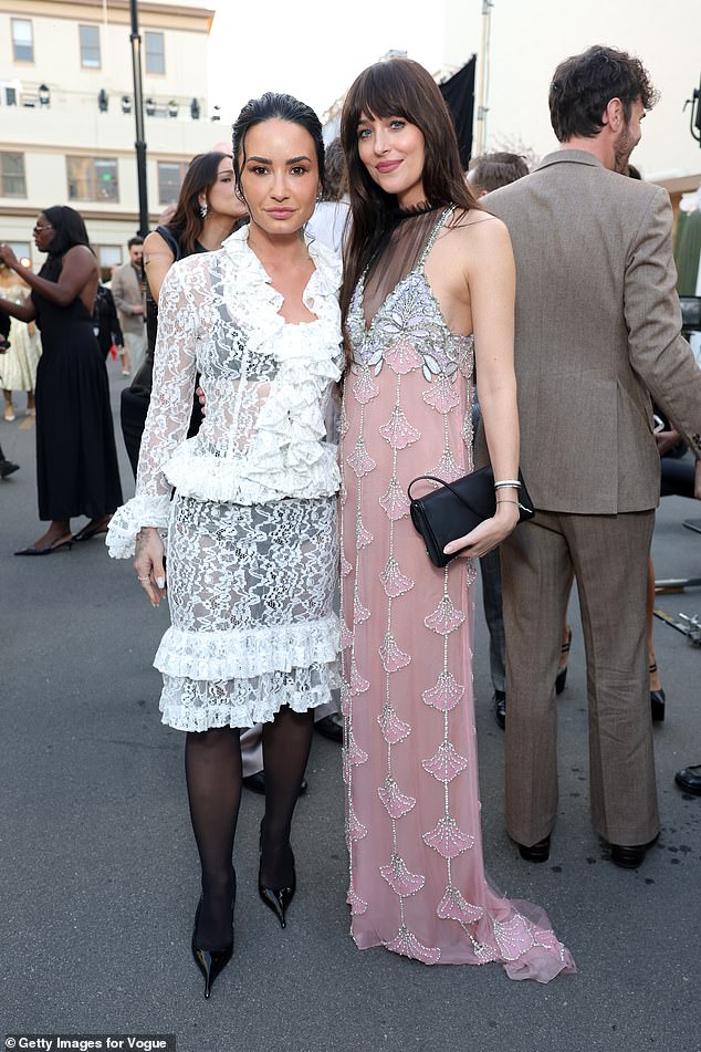 However, Dakota brushed off the news, as she put on a showstopping display at the fashion event, looking stunning in a pink beaded dress (pictured with Demi Lovato)