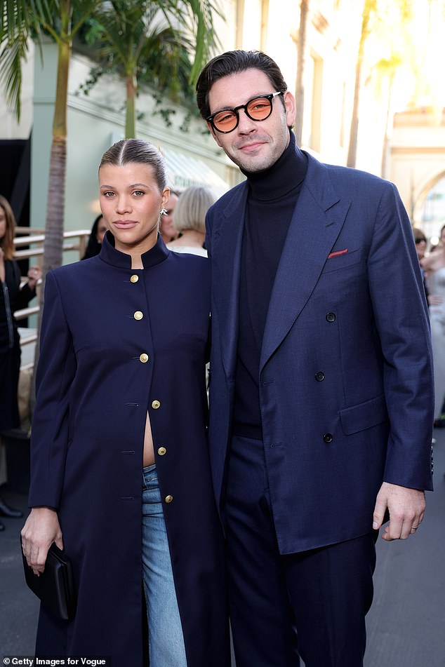 The mode, who is expected her second child, was joined by her husband Elliot Grainge at the runway event