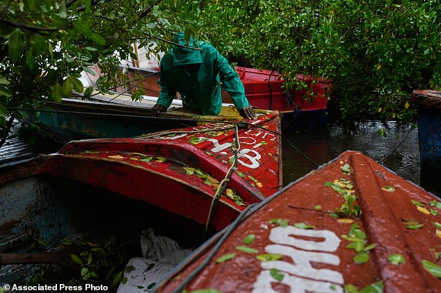 A fisherman ties boats in preparation for the forecasted arrival of Melissa in Old Harbour