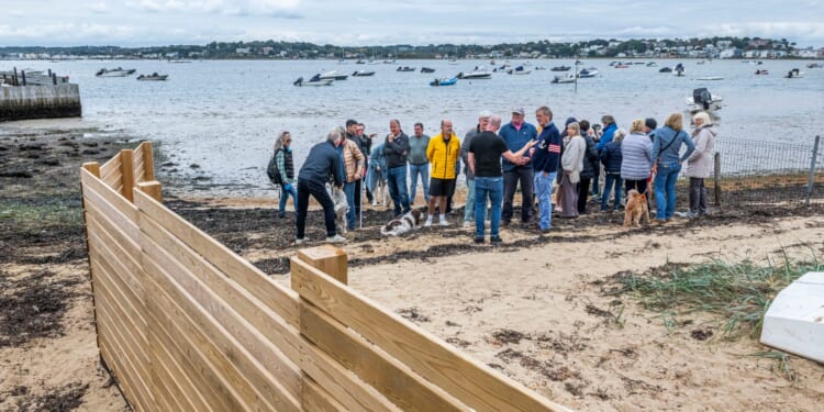 Millionaire neighbours locked in bitter row over 'oppressive' 40ft privacy fence suddenly built on popular UK beach