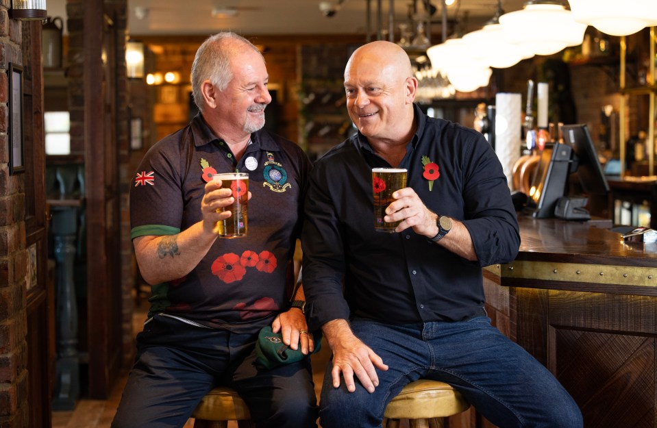 Ross Kemp and Royal Marine veteran and artist Colin Waite holding poppy pint glasses.
