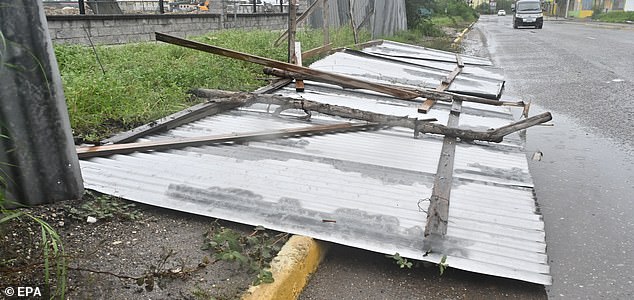 epa12486748 A fence lays on the road, damaged by the preliminary winds of Hurricane Melissa at Hellshire Fishing Beach, Portmore, Jamaica, 27 October 2025. Jamaican Prime Minister Andrew Holness said the government has a multifaceted plan to ensure a 'swift and effective' response to the storm's imminent impact on Monday night and forecast to be the island's strongest recorded storm.  EPA/RUDOLPH BROWN