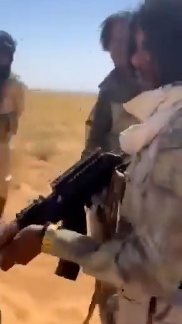 Screen grab shows a gunman pointing his weapon at unarmed civilians