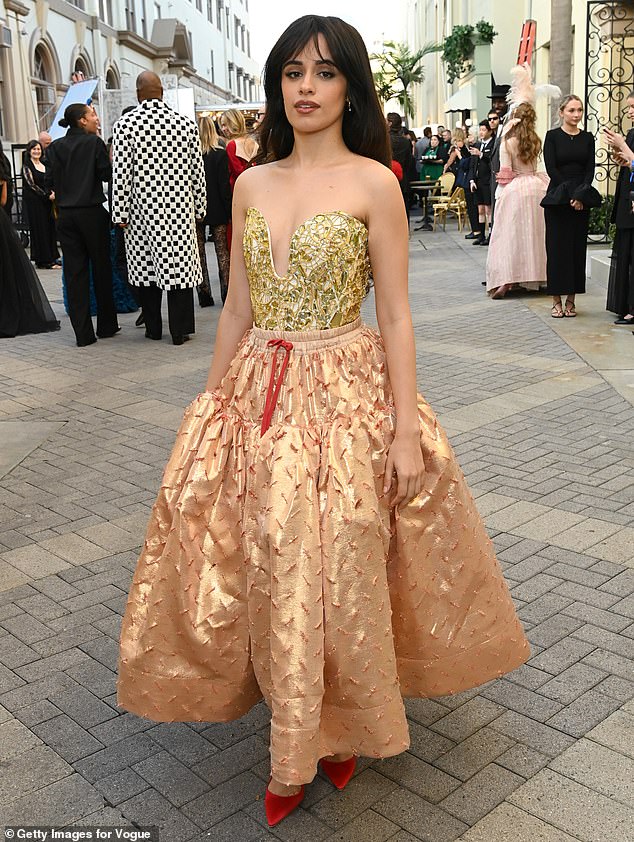 Singer Camila Cabello, 28, made a dramatic entrance in a strapless gold Vivienne Westwood gown, but was overwhelmed by her skirt