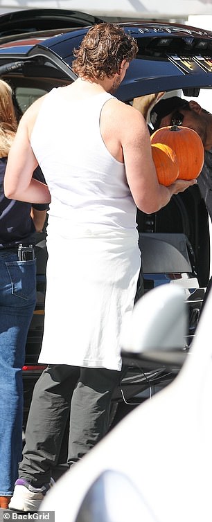 Christopher showed off his muscular back as he loaded the pumpkins in the trunk of their car