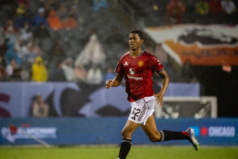 Manchester United player Isak Hansen-Aarøen running on the field in the rain.
