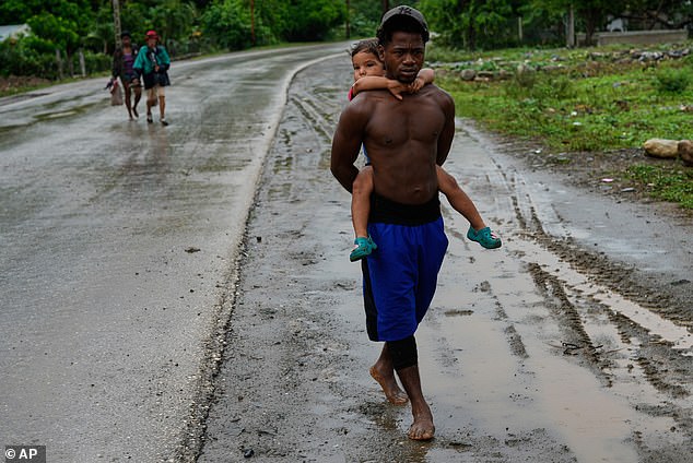 Residents in a Cuban town in the path of the storm were pictured earlier on Tuesday evacuating their homes