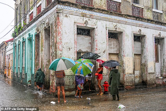 In Cuba, locals were seen waiting in the streets for food as rain poured down