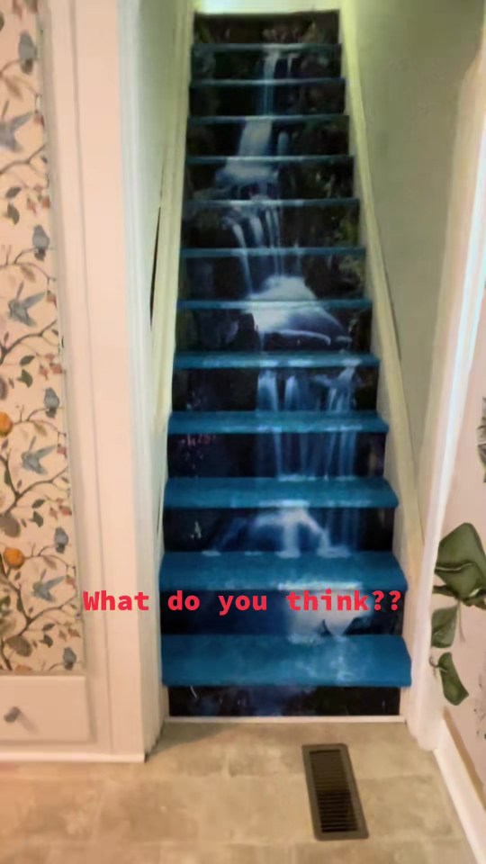 A staircase with blue carpet that depicts a waterfall, with "What do you think??" written in red text at the bottom.