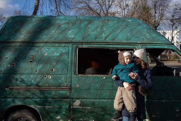 Yevheniia and her son Yehor in front of a van stricken with bullet holes. Reminders of the ongoing conflict are everywhere. Image provided by UNICEF