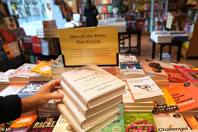 A customer picks the memoir book of Virginia Giuffre, 'Nobody's Girl' at a book store in London, Tuesday, October 21, 2025 six months after Giuffre died by suicide
