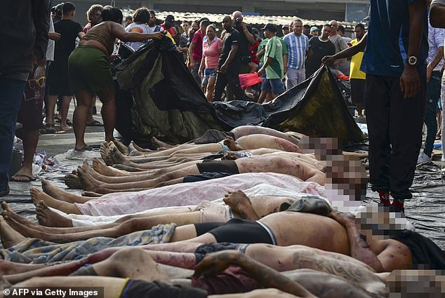 A man looks at the bodies of people killed during a police raid targeting the Comando Vermelho gang at the Complexo da Penha favela in Rio de Janeiro, Brazil, October 29, 2025