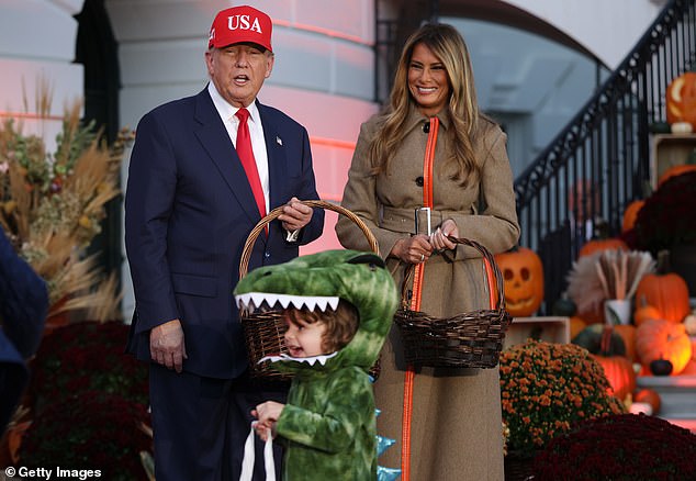Pictured: A small child grins while dressed as a dinosaur passing the President and First Lady