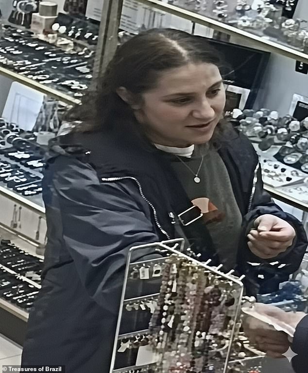 A female thief is seen speaking to the store manager before stealing  two iPhones from the pay counter