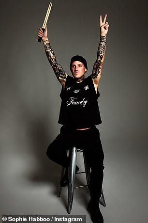 Before mimicking the moment Kourtney Kardashian held up a sign to tell husband Travis Barker she was expecting while he performed on stage