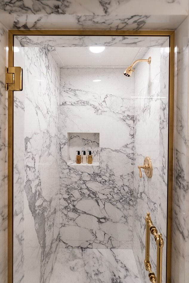 The new bathroom features an enclosed shower, with floor to ceiling marble and gold fixtures