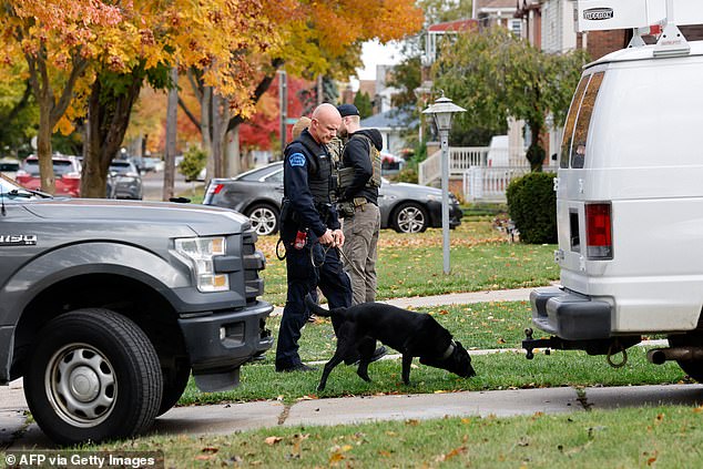 A sniffer dog and FBI agents outside a home in Dearborn, Michigan on October 31, 2025