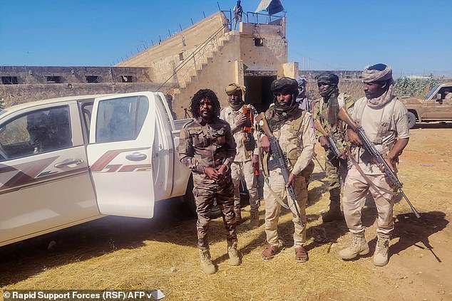 This handout picture released by the Sudanese Rapid Support Forces (RSF) on October 30, 2025, shows RSF members reportedly detaining a fighter known as Abu Lulu (L) in El-Fasher, in war-torn Sudan's western Darfur region