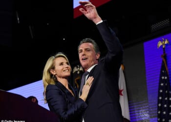 Gavin Newsom and his wife Jennifer Siebel Newsom wave to supporters during a gubernatorial election night event on November 6, 2018 in Los Angeles