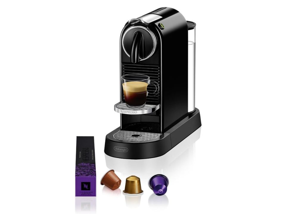 Black Nespresso coffee machine with an espresso cup and various coffee pods.