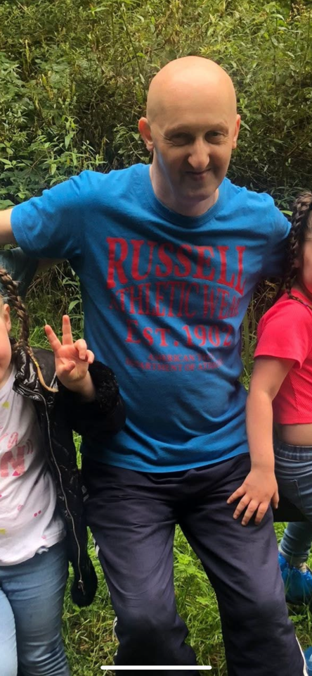 Adrian Daulby smiling and wearing a blue Russell Athletic t-shirt.