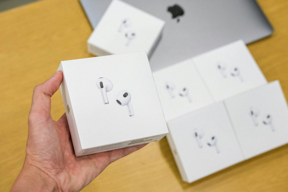 Hand holding an Apple AirPods box.