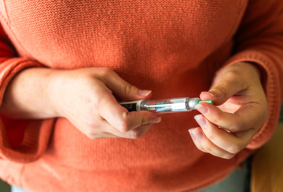 Woman's hands holding a weight loss injection pen.