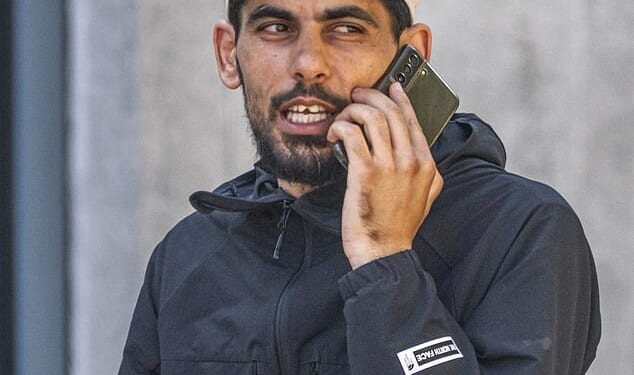 Libyan migrant Ibrahim Zouari (pictured outside court wearing a black North Face jacket), 35, has been jailed for 15 months after he brandished a chair and chased migrant hotel staff with a knife