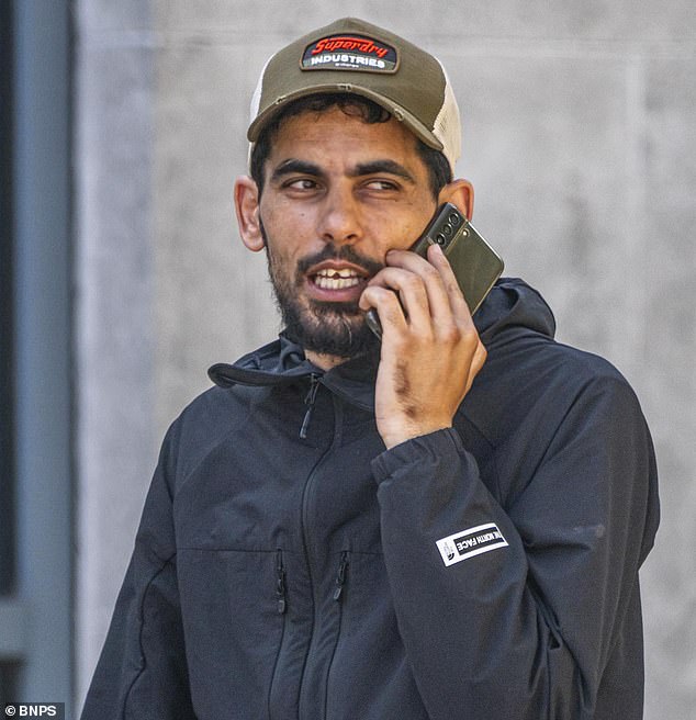 Libyan migrant Ibrahim Zouari (pictured outside court wearing a black North Face jacket), 35, has been jailed for 15 months after he brandished a chair and chased migrant hotel staff with a knife