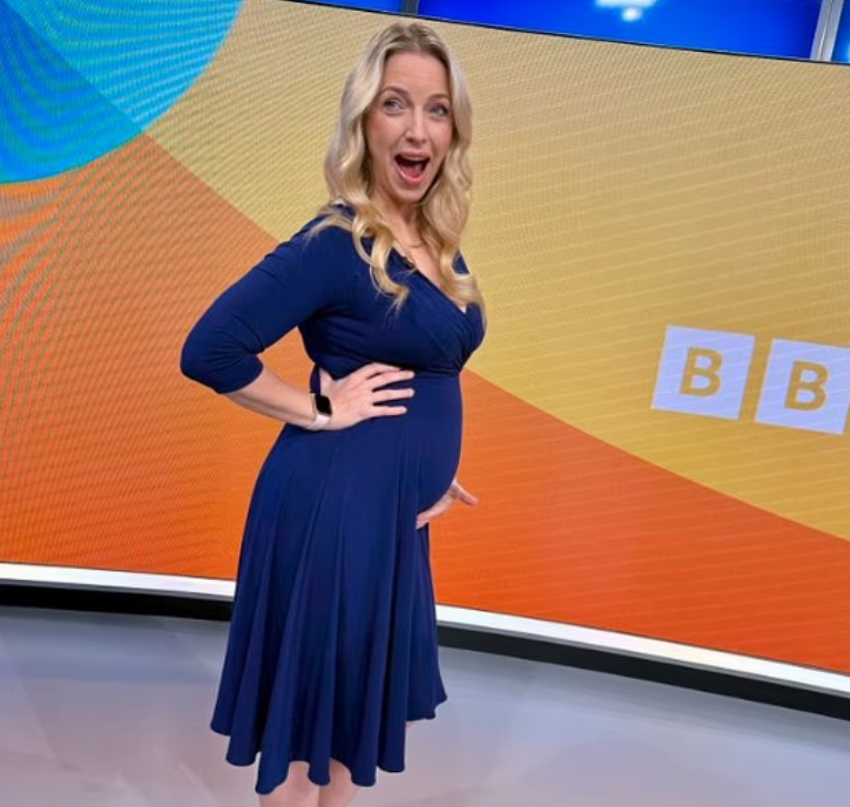 Pregnant woman in a navy dress, standing in front of a BBC background.