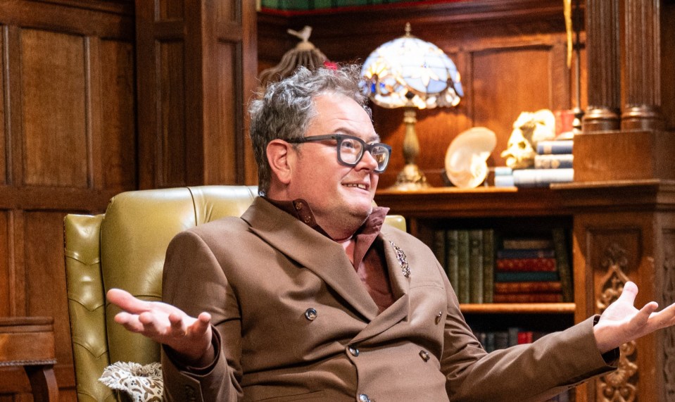 Two people are sitting in leather armchairs in a luxurious room.