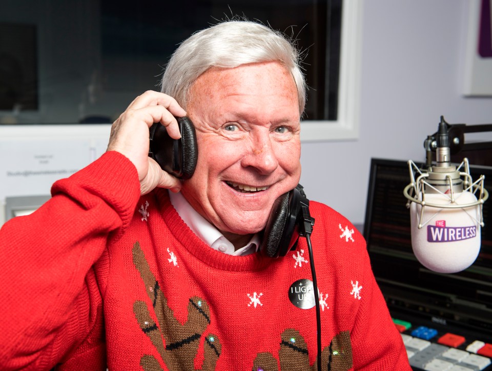 a man wearing a red sweater is talking into a wireless microphone