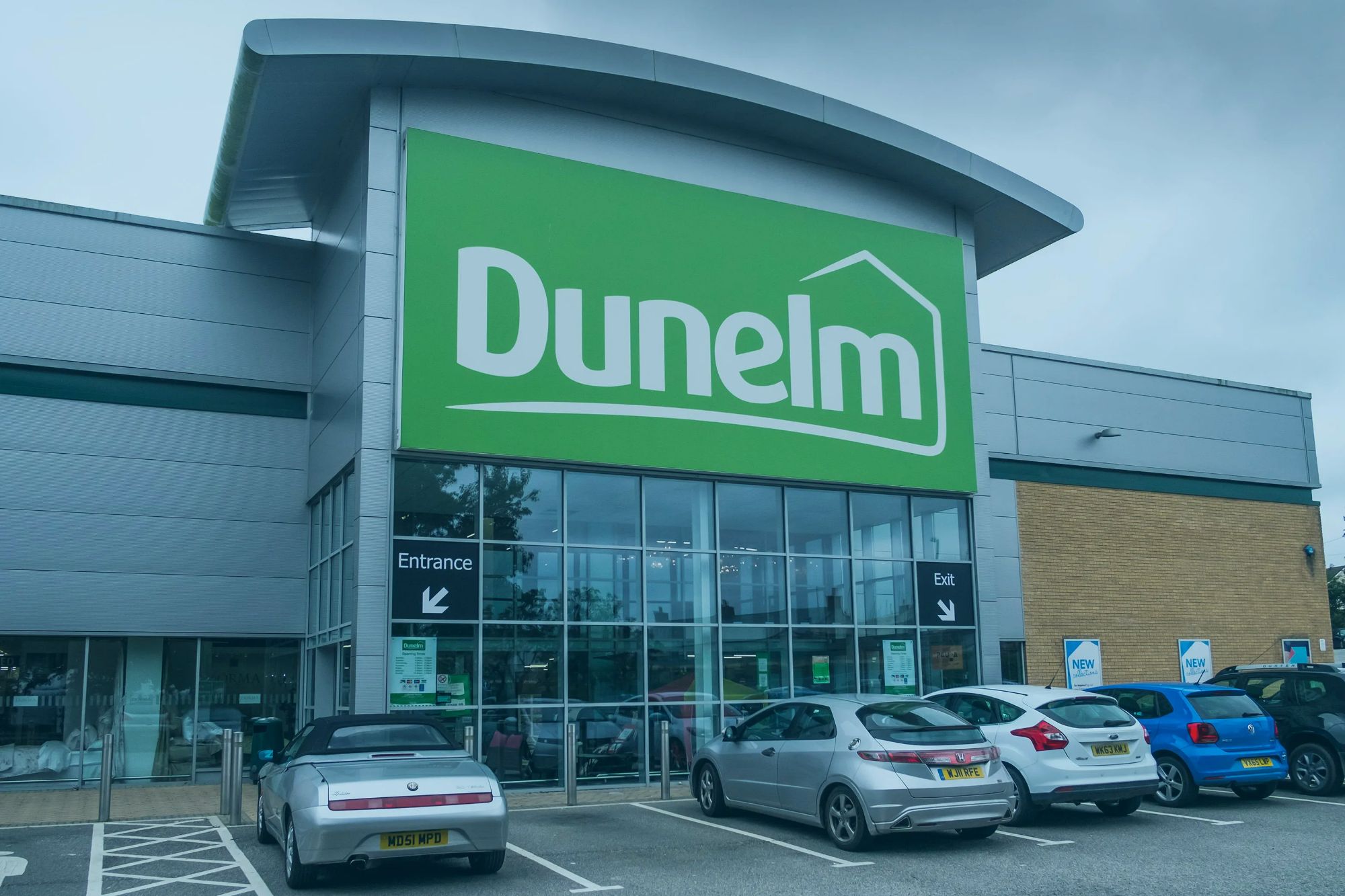 An image collage containing 1 images, Image 1 shows Dunelm retail outlet with signage for entrance and exit, and parked cars in the foreground