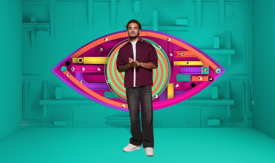 Big Brother contestant Marcus posing in front of a giant eye logo.