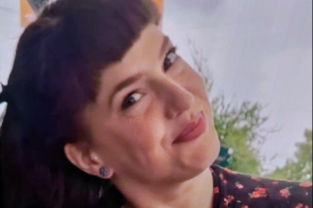 Sheila, 35, with shoulder-length dark brown hair and blue eyes, wearing a black top with red floral patterns.