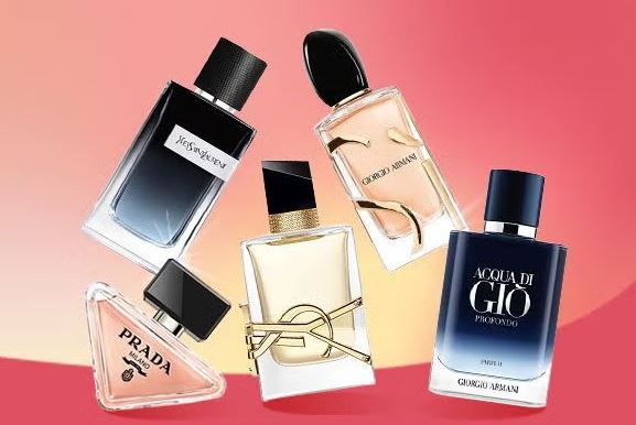 A collection of luxury perfume bottles, including Giorgio Armani, Yves Saint Laurent, and Prada, on a pink and orange background.