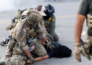 A person is detained by law enforcement officers in Chicago's Brighton Park neighborhood in Chicago on Oct. 4, 2025.