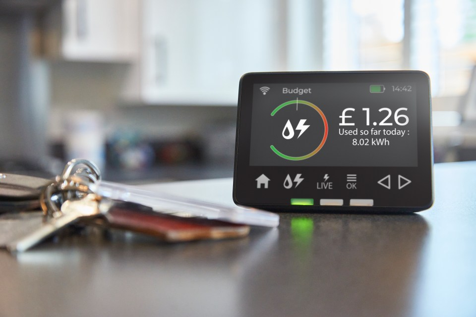 A smart energy monitor displaying a cost of £1.26 and 8.02 kWh used today, with keys in the foreground.