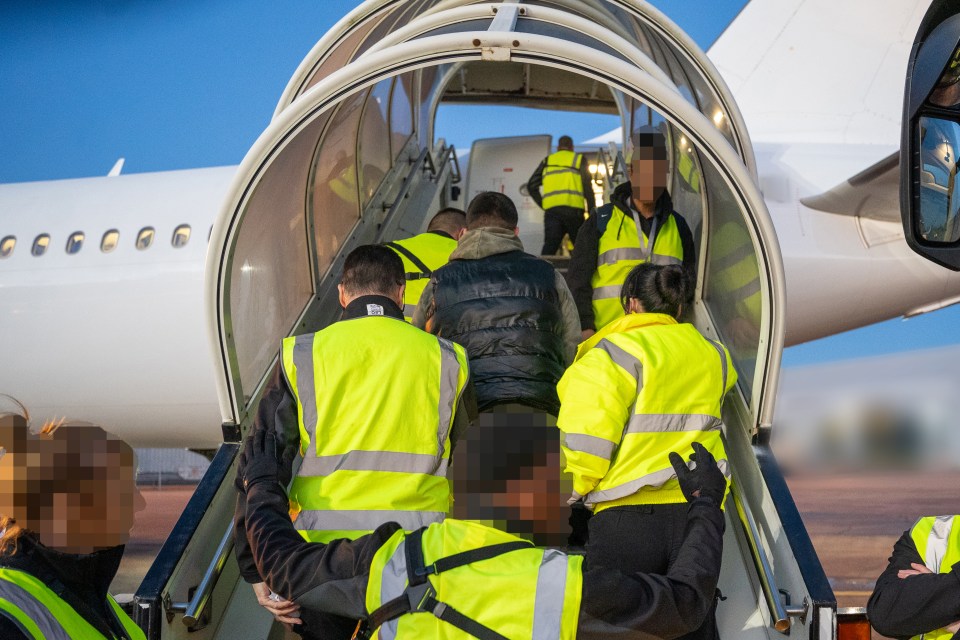 People wearing high-visibility vests escorting individuals up the stairs into an airplane.