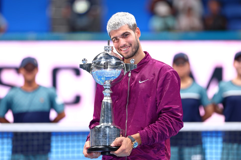 Carlos Alcaraz holding the Kinoshita Group Japan Open Tennis Championships trophy.