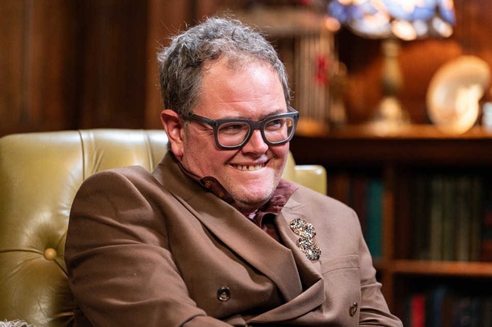 Euan Cherry, wearing a brown jacket, smiling.