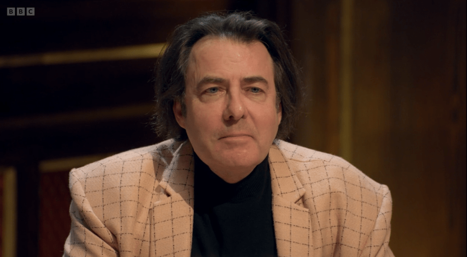 Jonathan Ross in a light peach blazer with a black turtleneck.