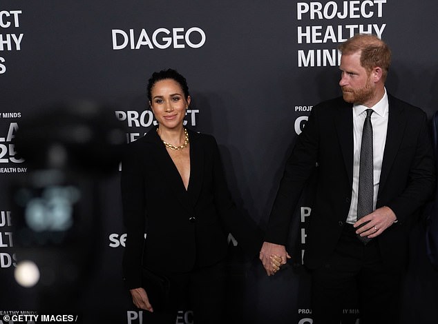 As they walked the New York step-and-repeat, Meghan paused as Harry appeared to glower and appeared to whisper 'come on now'