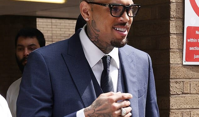 Chris Brown is allowed to return to the US on bail after being charged over an alleged unprovoked attack on a music producer in a London nightclub (Pictured: Brown attending Southward Crown Court in May this year)