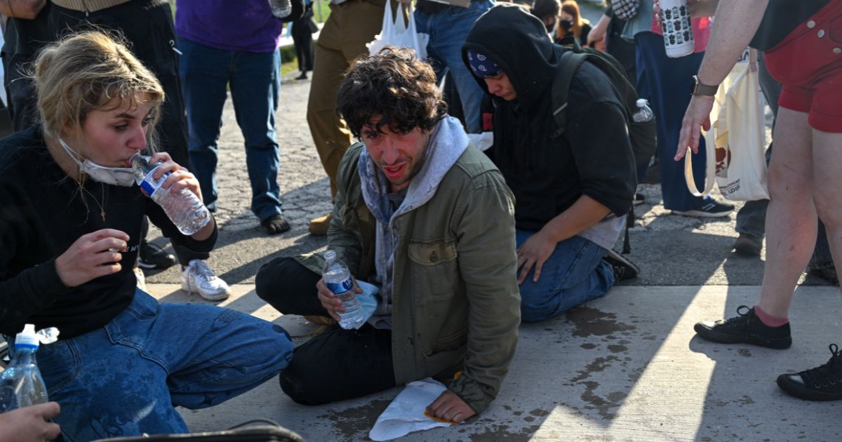Demonstrators protesting outside the Immigration and Customs Enforcement facility, including Democratic congressional candidate Kat Abughazaleh, 26, react after being tear-gassed on Sept. 19, 2025, in Broadview, Illinois.