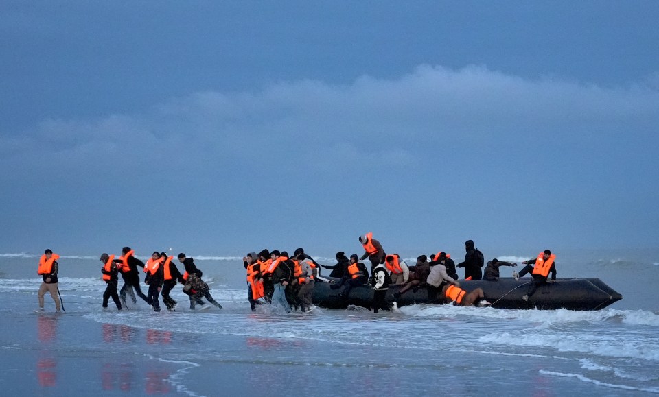 People thought to be migrants flee a deflating small boat following an attempt to cross the Channel in Gravelines, France.