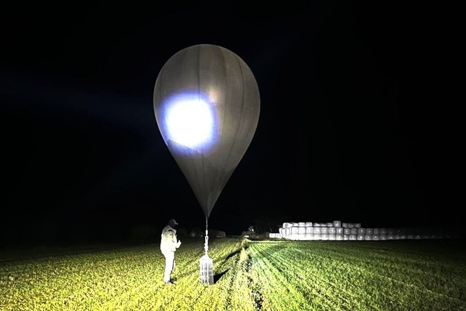 An officer inspecting a balloon used to carry cigarettes.
