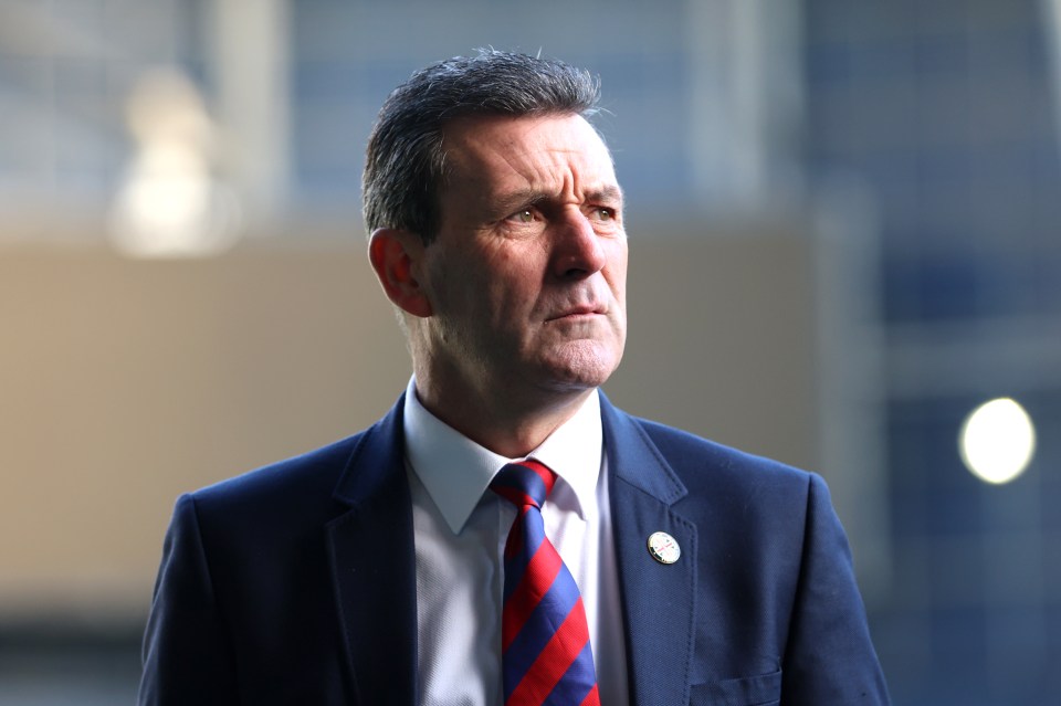 Tommy Widdrington, Manager of Aldershot Town, looks on.