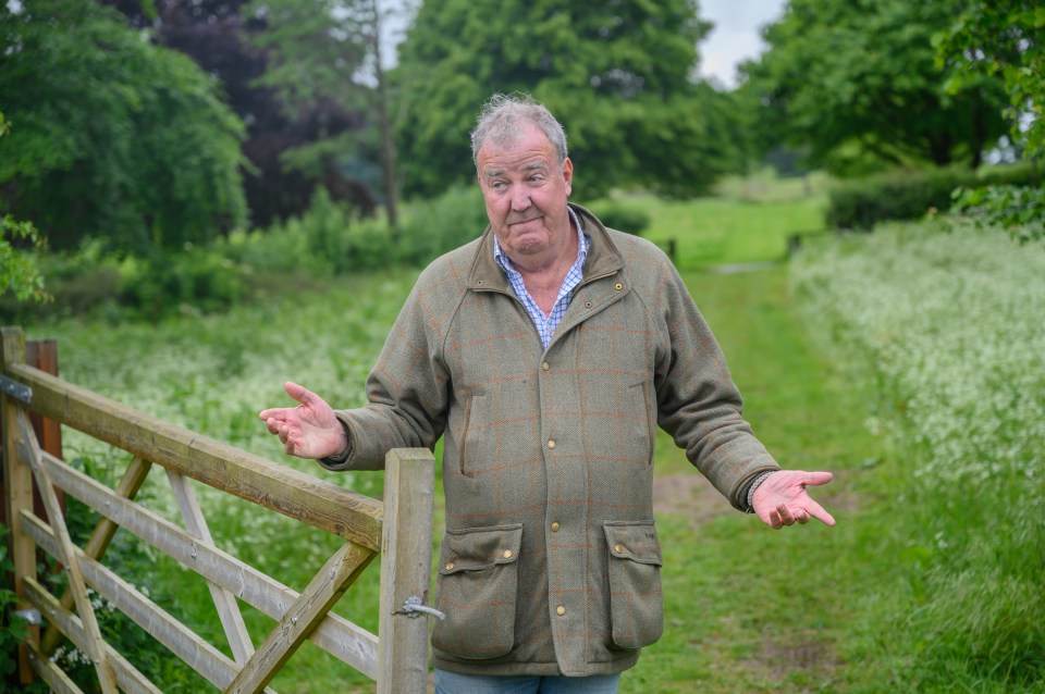 Jeremy Clarkson shrugging his shoulders with hands open on his farm.