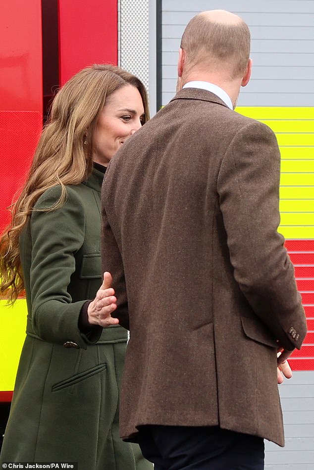 During their trip to Northern Ireland, Kate was photographed affectionately placing her hand on William's back before the royal couple rode in a fire truck and watched trainee firefighters take part in drills.
